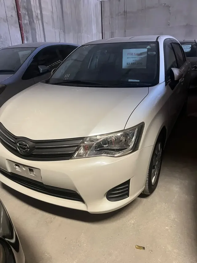 2013 Toyota Corolla Axio, white sedan for sale at Rahaman & Sons, Success — in stock